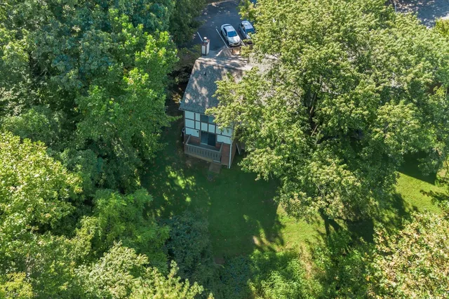 a front view of a house with barbeque grill and wooden fence