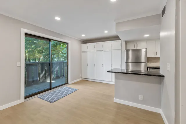 a view of kitchen with stainless steel appliances granite countertop cabinets and window