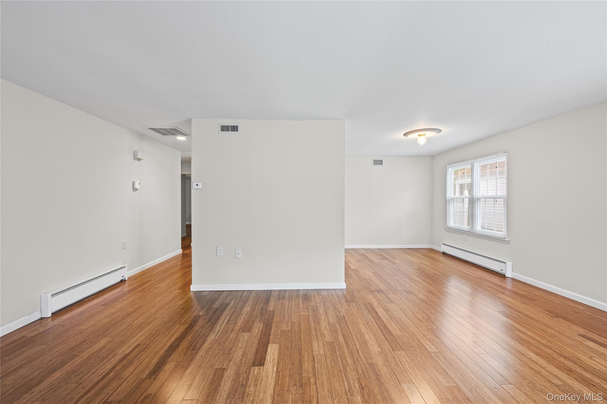 220 Belfast Lane Ridge, NY 11961 - Photo 14 of 44 wooden floor in an empty room with a window