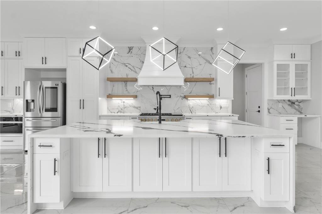 3671 Hamilton Mill Road Buford, GA 30519 - Photo 20 of 111 a kitchen with stainless steel appliances granite countertop a sink a stove and a refrigerator