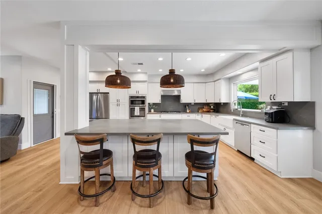 a kitchen with stainless steel appliances a table and chairs in it