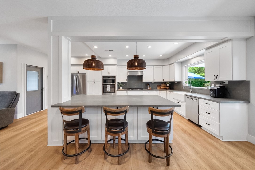 a kitchen with stainless steel appliances a table and chairs in it