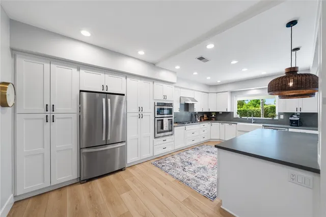 a kitchen with stainless steel appliances granite countertop a refrigerator sink and cabinets