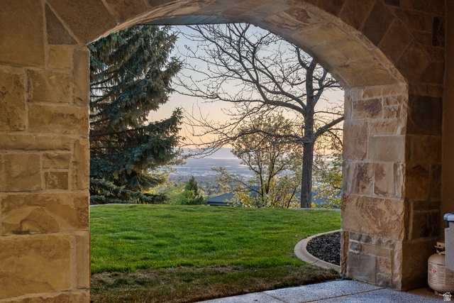 1714 Ridge Point Drive Bountiful, UT 84010 - Photo 119 of 132 Stone archway with natural stone masonry, concrete patio, and a manicured lawn