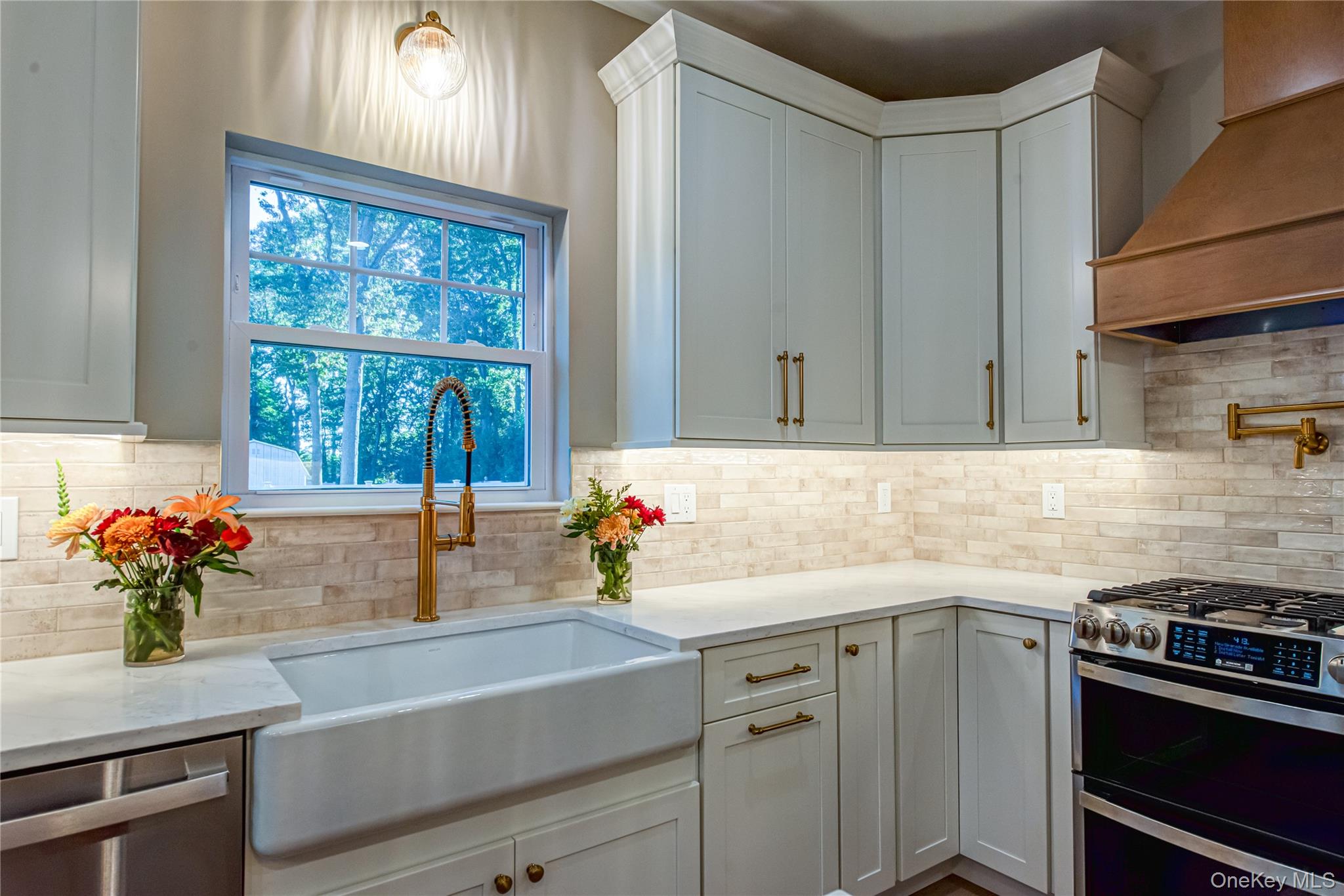 64 Blydenburgh Road Centereach, NY 11720 - Photo 24 of 44 Kitchen with appliances with stainless steel finishes, custom exhaust hood, light stone counters, white cabinets, and decorative light fixtures. For Marketing Purposes!