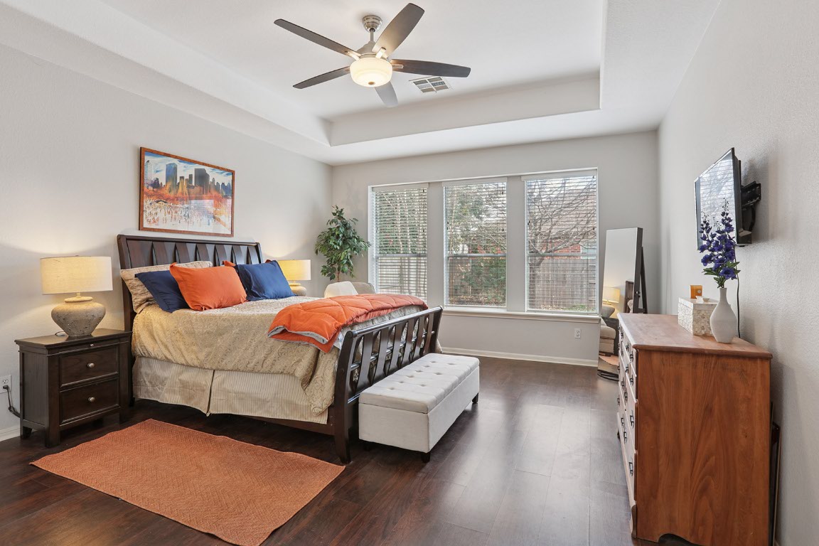 11217 Terrace Meadow Way Manor, TX 78653 - Photo 15 of 33 Bedroom with dark wood-style flooring, a raised ceiling, and a ceiling fan