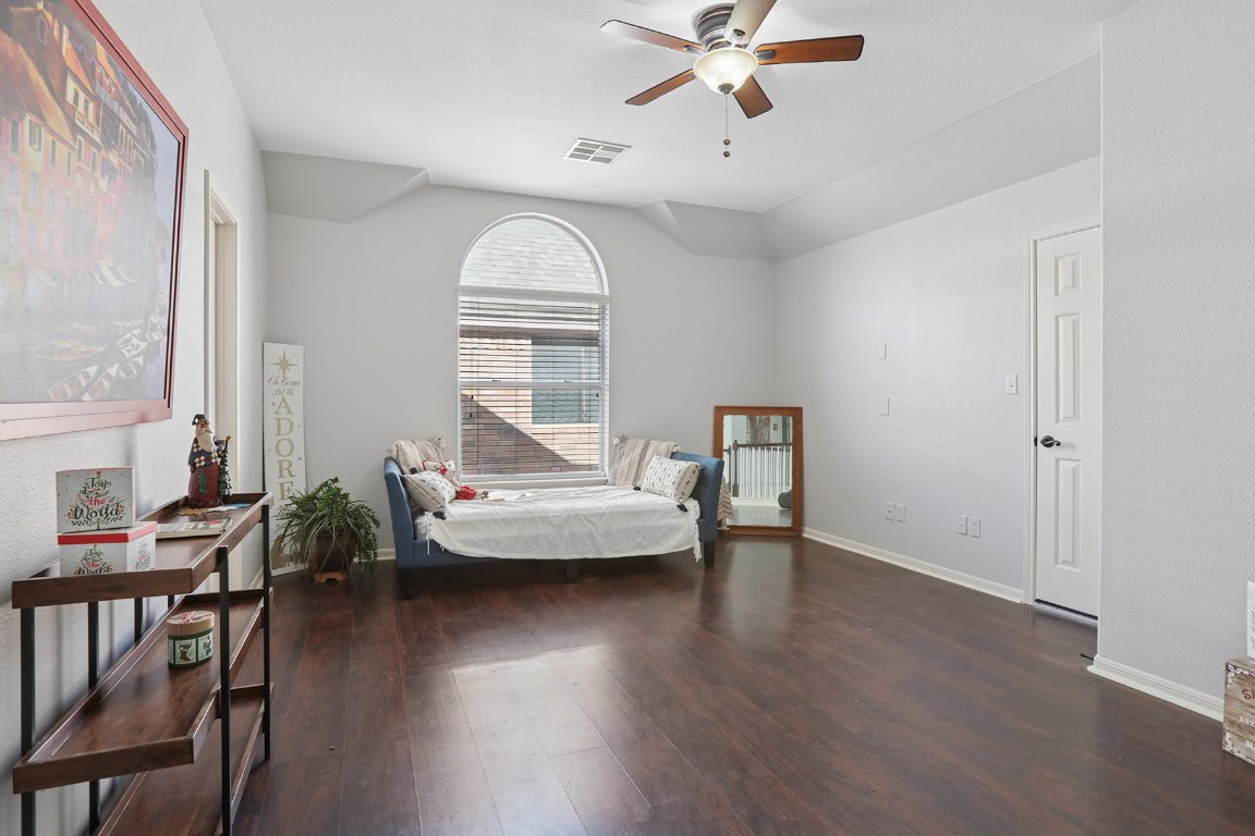 11217 Terrace Meadow Way Manor, TX 78653 - Photo 16 of 33 Bedroom with dark wood-style floors, ceiling fan, and vaulted ceiling