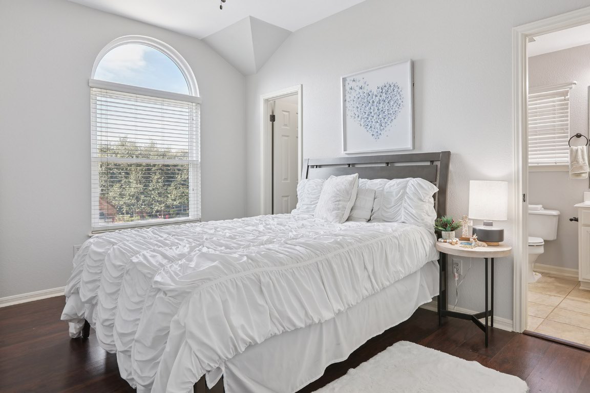 11217 Terrace Meadow Way Manor, TX 78653 - Photo 17 of 33 Bedroom with vaulted ceiling, dark wood-type flooring, and ensuite bathroom