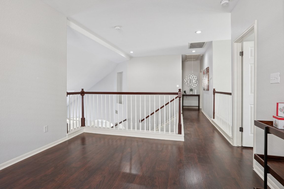 11217 Terrace Meadow Way Manor, TX 78653 - Photo 20 of 33 Corridor featuring attic access, dark wood-style flooring, vaulted ceiling, and recessed lighting