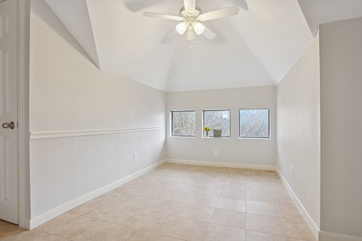11217 Terrace Meadow Way Manor, TX 78653 - Photo 26 of 33 Spare room with ceiling fan, light tile patterned flooring, and vaulted ceiling