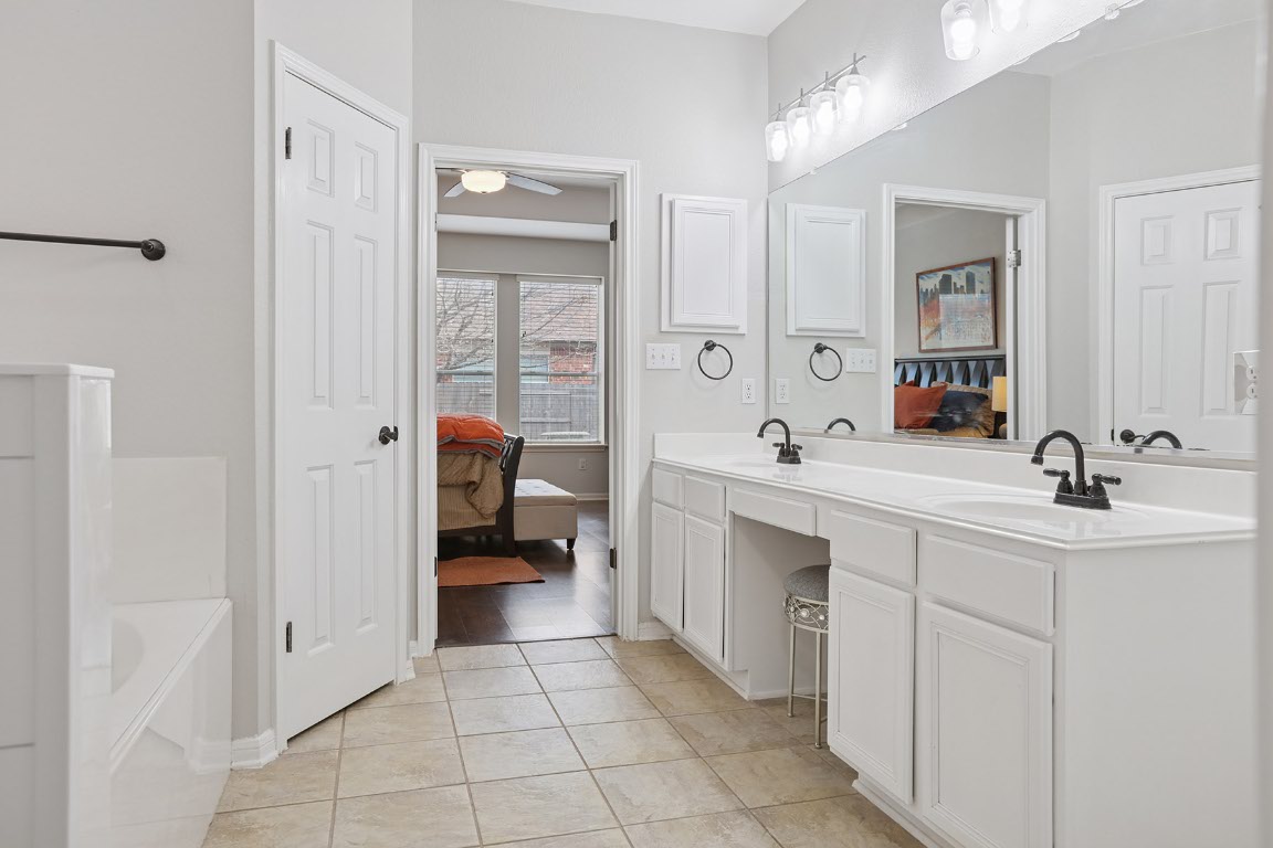 11217 Terrace Meadow Way Manor, TX 78653 - Photo 29 of 33 Bathroom with ensuite bathroom, double vanity, a bath, and a ceiling fan