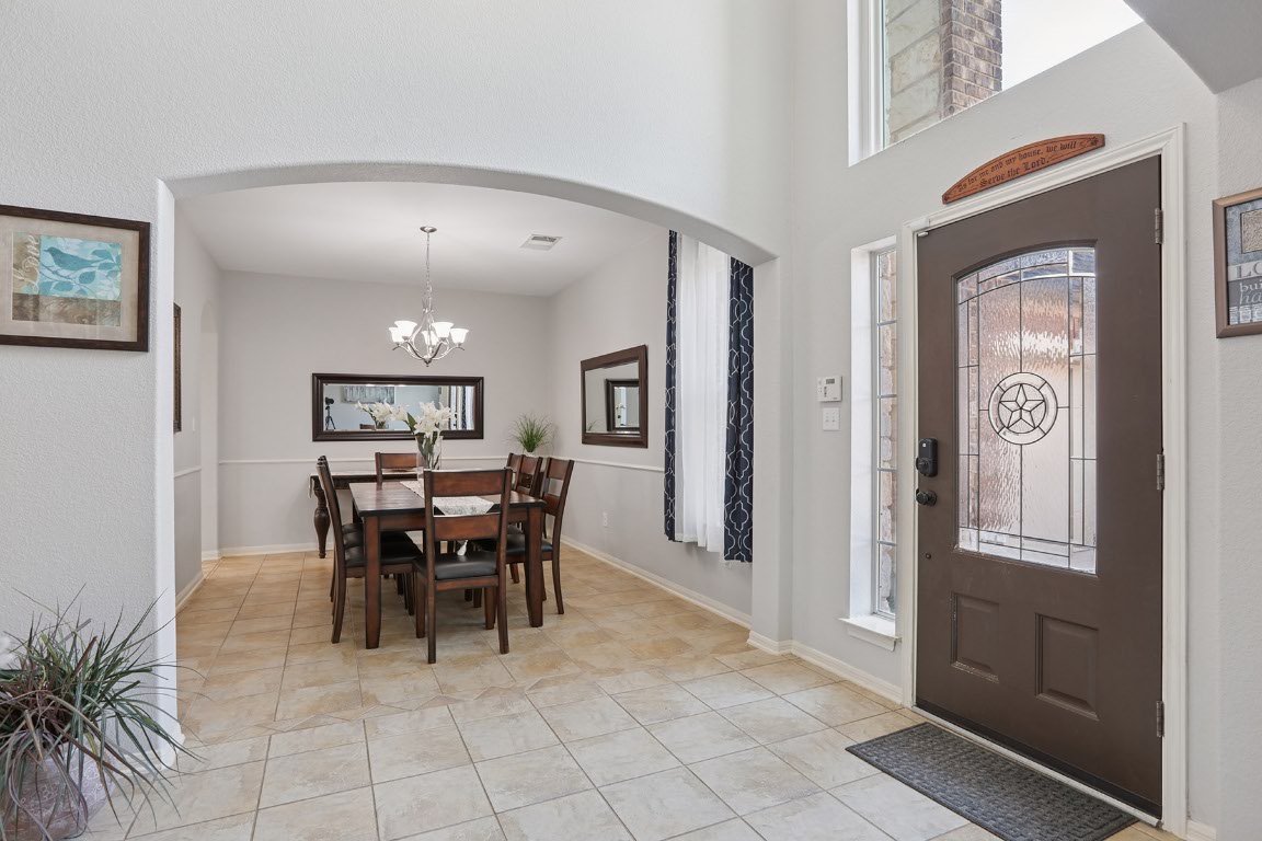 11217 Terrace Meadow Way Manor, TX 78653 - Photo 3 of 33 Entrance foyer featuring arched walkways, a chandelier, and light tile patterned floors