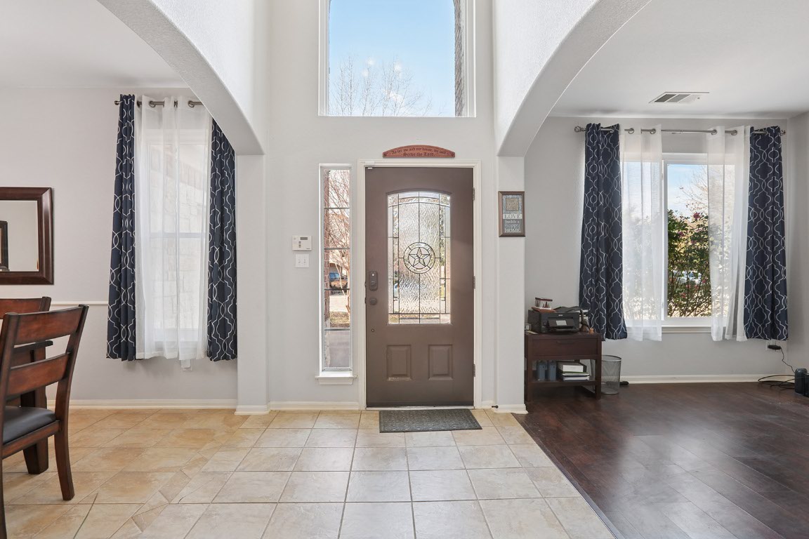 11217 Terrace Meadow Way Manor, TX 78653 - Photo 4 of 33 Foyer entrance featuring arched walkways, tile patterned flooring, and a towering ceiling