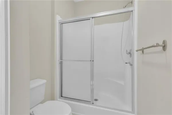 a bathroom with a granite countertop toilet and a shower