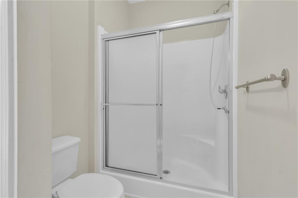 4557 Caleb Crossing, Unit 71 Powder Springs, GA 30127 - Photo 16 of 23 a bathroom with a granite countertop toilet and a shower