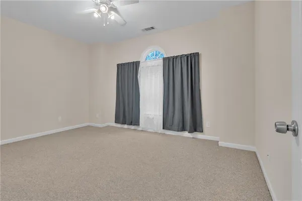 an empty room with a ceiling fan and a window