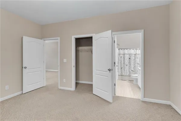 an empty room with a bathroom and mirror