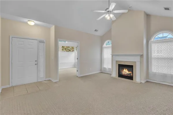 an empty room with windows and a fireplace