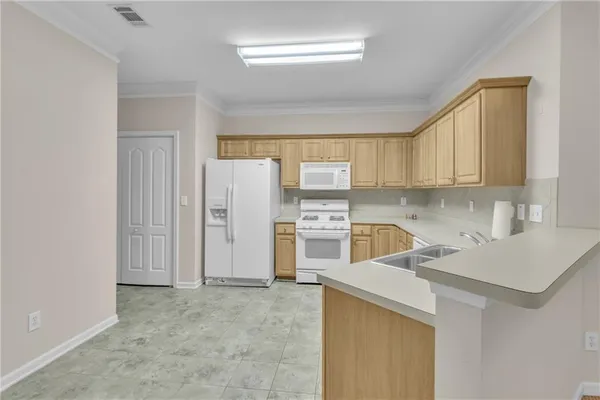 a kitchen with a sink a stove a refrigerator and cabinets
