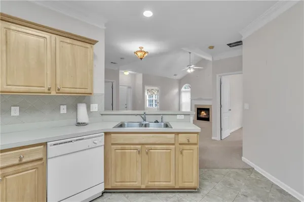 a kitchen with a sink dishwasher and cabinets with wooden floor