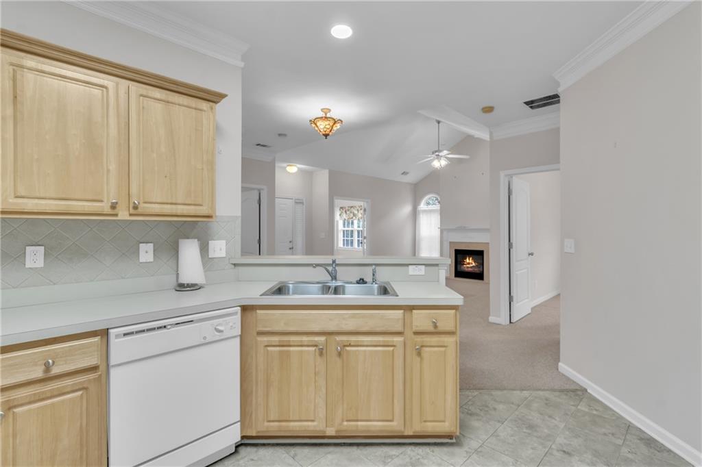 4557 Caleb Crossing, Unit 71 Powder Springs, GA 30127 - Photo 10 of 23 a kitchen with a sink dishwasher and cabinets with wooden floor
