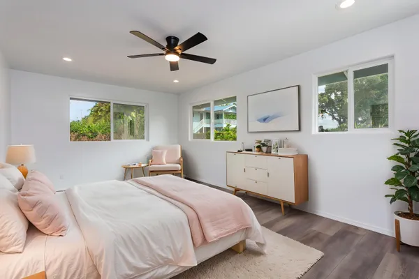 a bedroom with a large bed and a potted plant