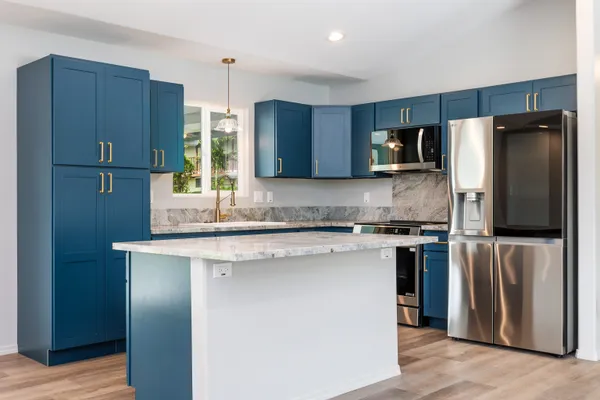 a kitchen with stainless steel appliances granite countertop a refrigerator a sink and a stove