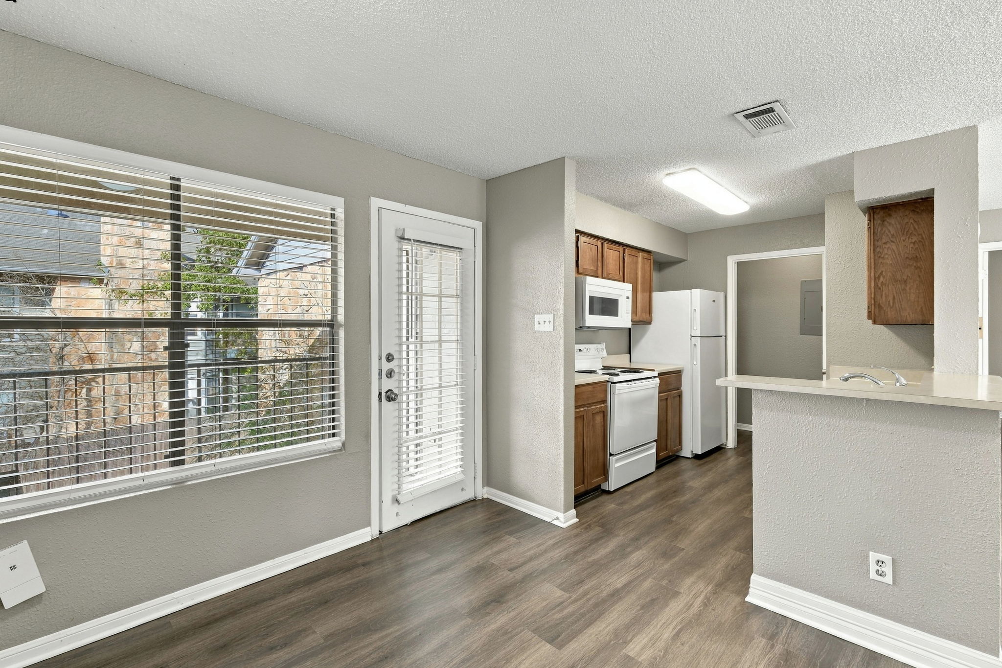 8804 Schick Road, Unit C Austin, TX 78729 - Photo 5 of 17 An open layout connects the dining space to a kitchen featuring warm wood cabinetry.