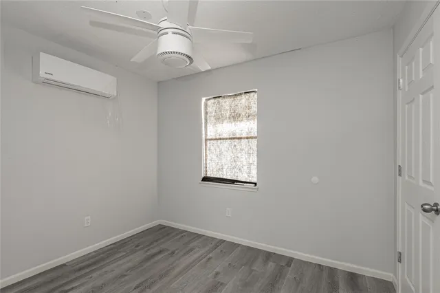 an empty room with a window and wooden floor