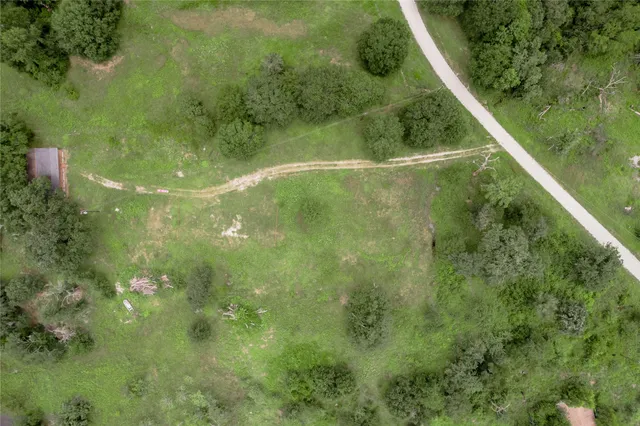 an aerial view of residential house with outdoor space and trees all around