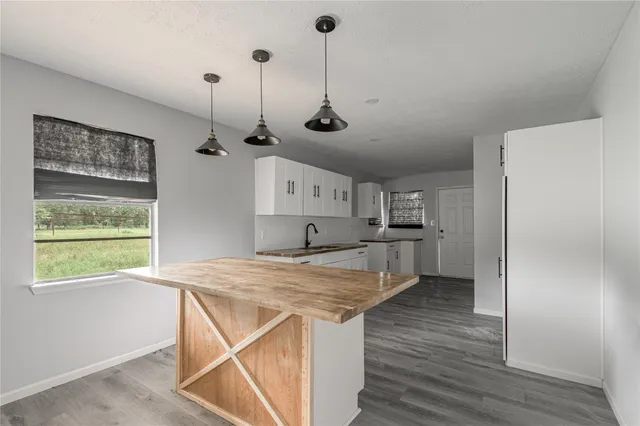 a view of a kitchen with wooden floor and a window