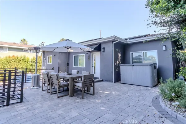 a view of a patio with a table chairs and a barbeque