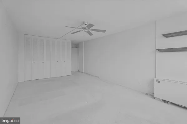 an empty room with a ceiling fan and a window