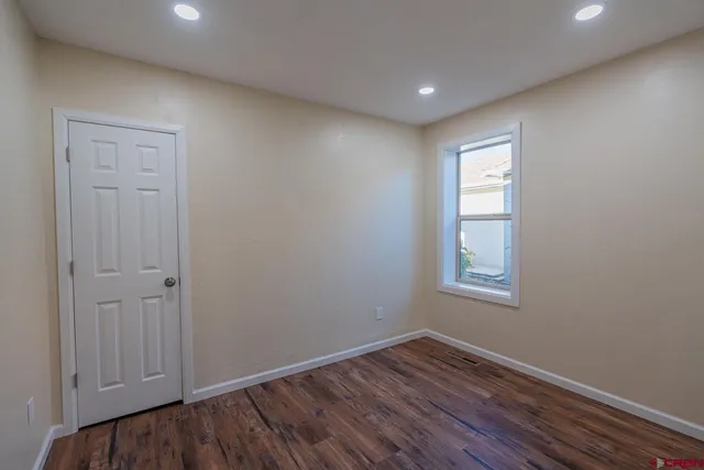 a view of empty room with wooden floor