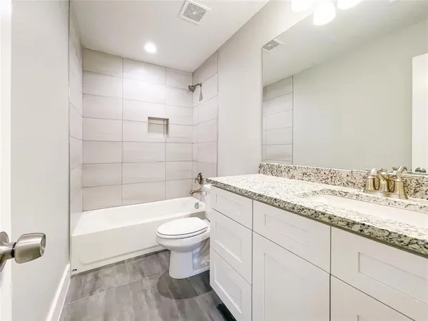 a bathroom with a granite countertop sink toilet and shower