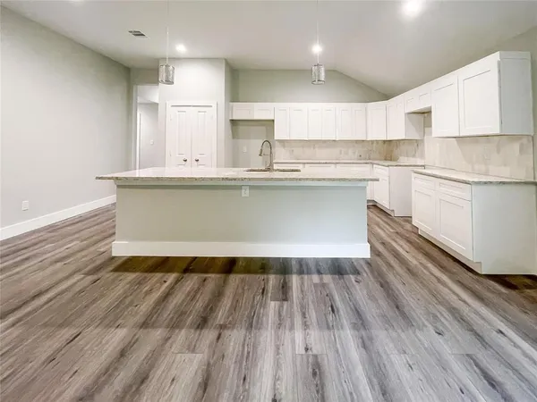 a kitchen with wooden floor and window