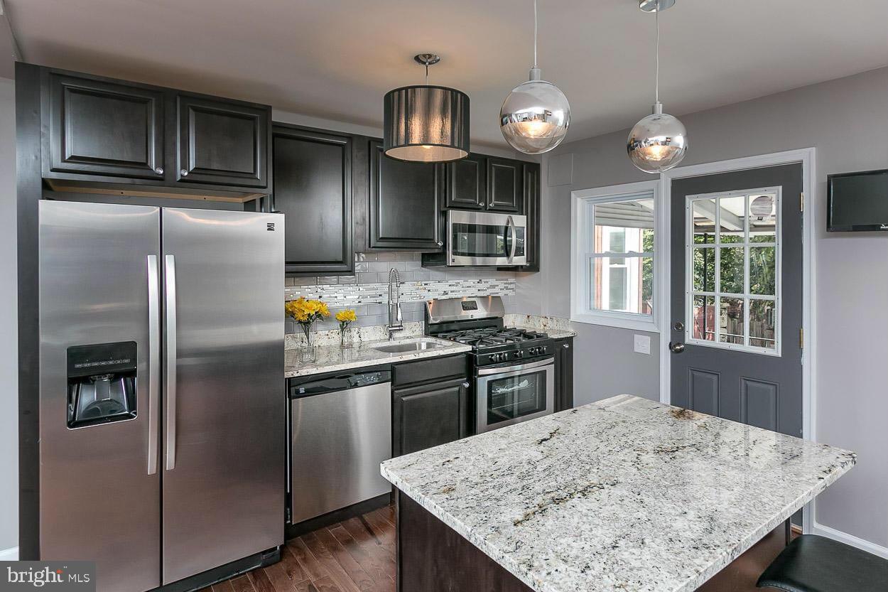 3815 Yolando Road Baltimore, MD 21218 - Photo 1 of 20 a kitchen with stainless steel appliances granite countertop a sink a stove and refrigerator