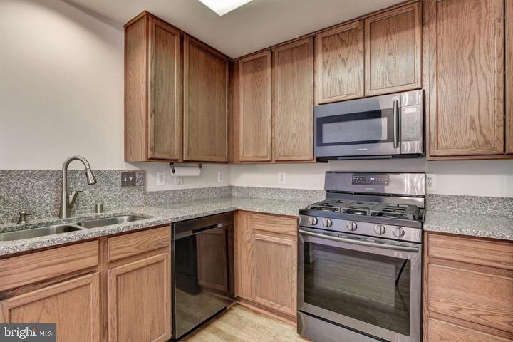 576 Orchard Ridge Drive, Unit 100 Gaithersburg, MD 20878 - Photo 11 of 44 a kitchen with granite countertop cabinets stainless steel appliances and wooden cabinets