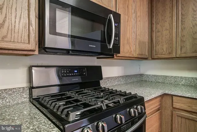 a kitchen with stainless steel appliances granite countertop a stove and a microwave