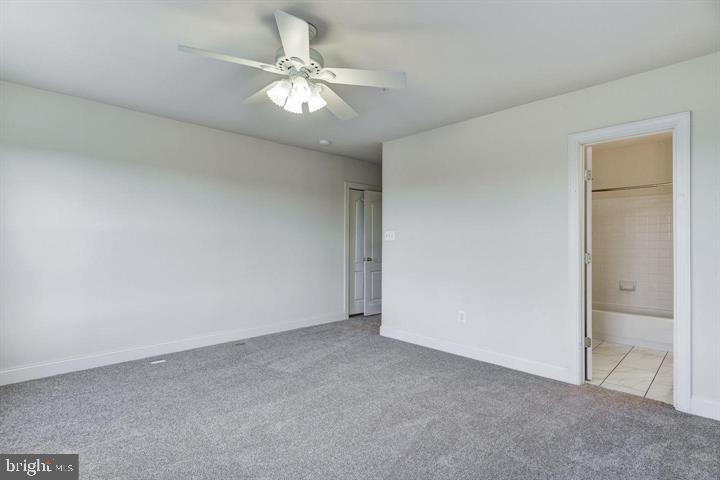 576 Orchard Ridge Drive, Unit 100 Gaithersburg, MD 20878 - Photo 18 of 44 an empty room with a chandelier fan and windows