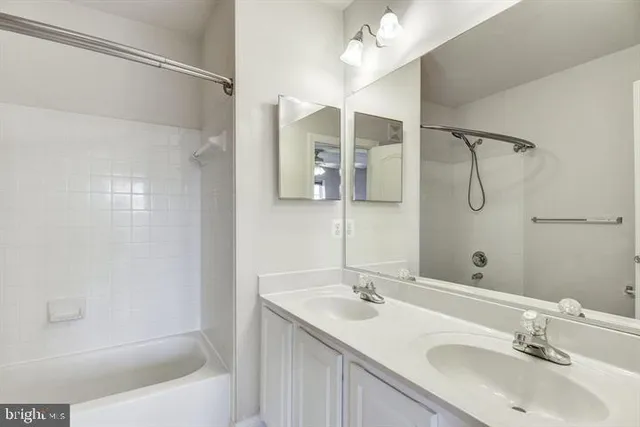 a bathroom with a bathtub shower sink vanity and mirror