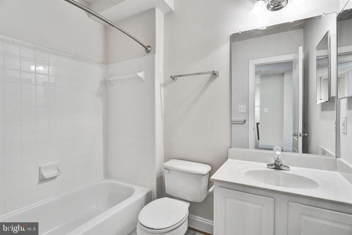 576 Orchard Ridge Drive, Unit 100 Gaithersburg, MD 20878 - Photo 26 of 44 a bathroom with a toilet a sink a mirror a bathtub and vanity