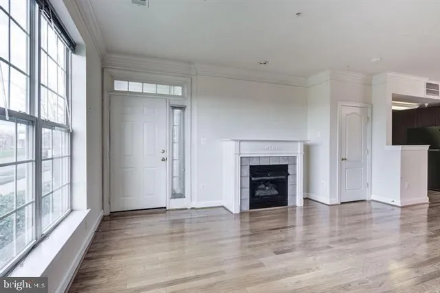 a view of a livingroom with a fireplace wooden floor and window