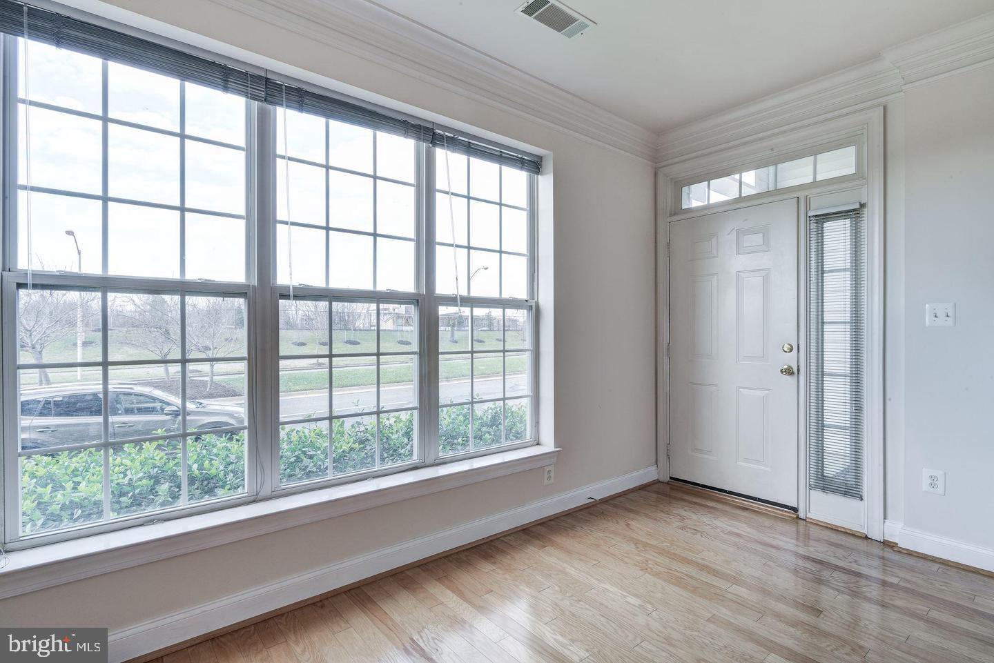 576 Orchard Ridge Drive, Unit 100 Gaithersburg, MD 20878 - Photo 7 of 44 a view of an empty room with wooden floor and a window
