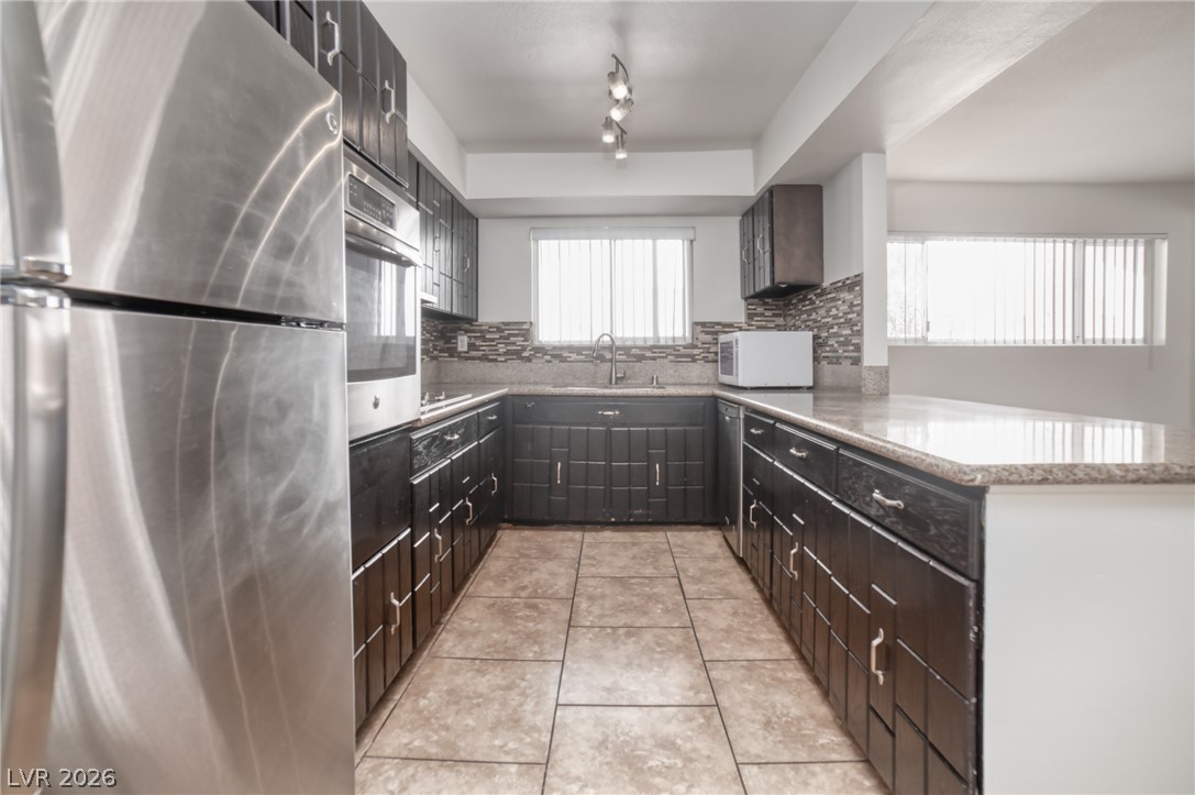 3556 Ruth Drive Las Vegas, NV 89121 - Photo 8 of 21 Well-appointed kitchen featuring sleek dark cabinetry, durable granite counters, and integrated stainless steel appliances.