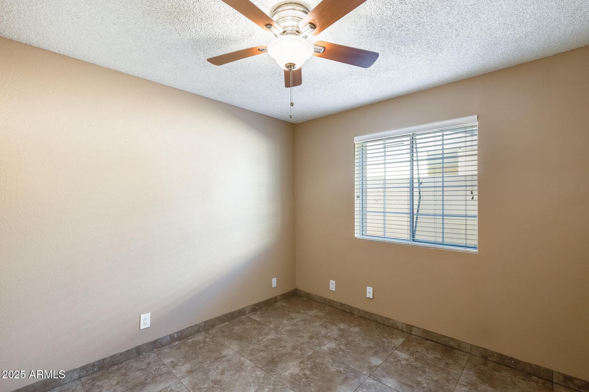 17633 North 15th Avenue Phoenix, AZ 85023 - Photo 14 of 32 an empty room with a window and a ceiling fan