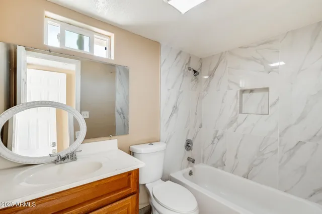 a bathroom with a sink a toilet and a mirror