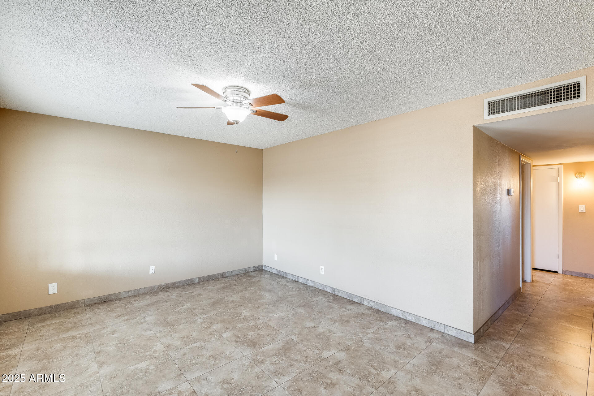 17633 North 15th Avenue Phoenix, AZ 85023 - Photo 6 of 32 an empty room with a chandelier fan and windows