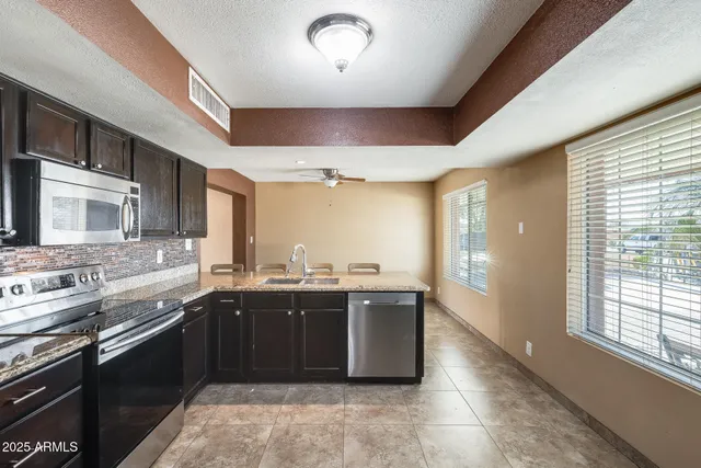 a large kitchen with stainless steel appliances granite countertop a sink and stove