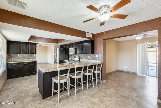 a kitchen with a counter space a sink stainless steel appliances and cabinets